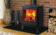 A multi fuel stove with a roaring fire with firewood